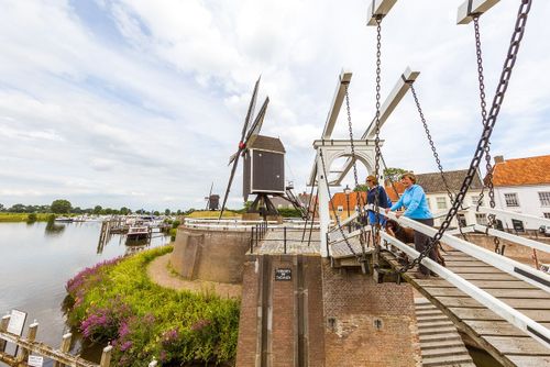 Spaziergang durch Heusden, zwei Personen auf der Brücke bei der Mühle