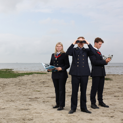 3 studenten in uniform op het strand van Terschelling