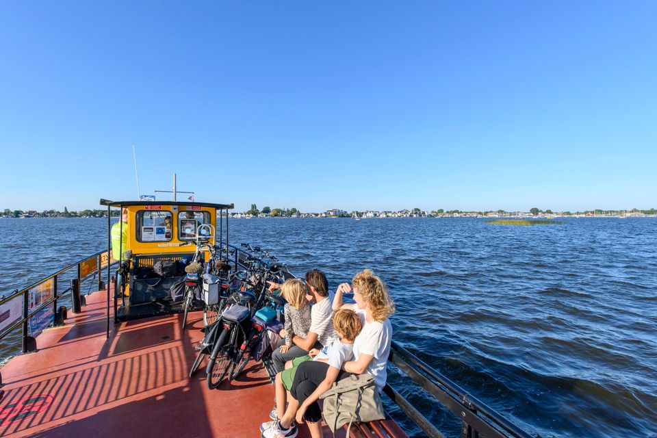 Gezin geniet van het uitzicht aan boord van de Fietsboot op de Loosdrechtse Plassen