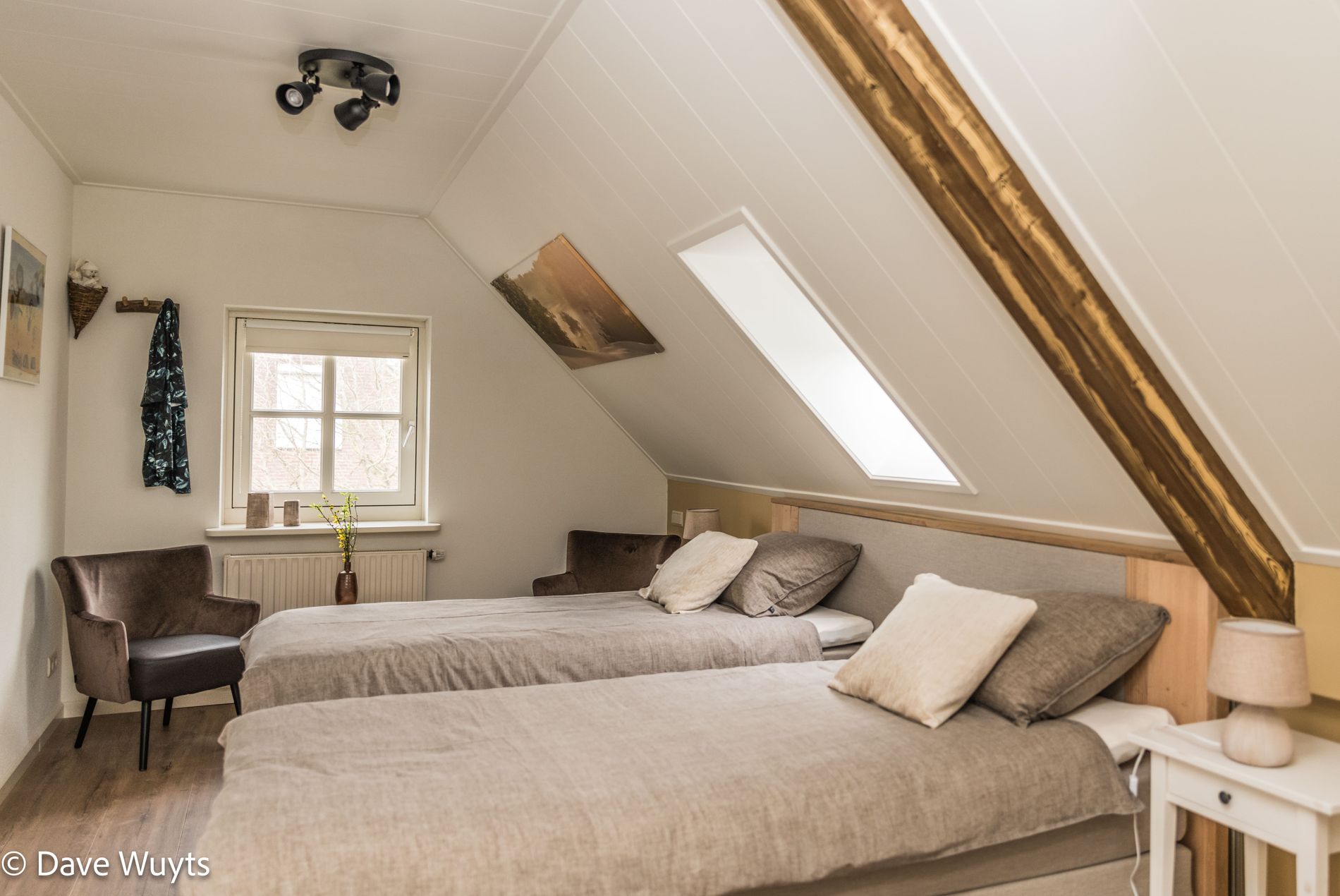 Slaapkamer met 2 één-persoons bedden onder de schuine kap met dakraam.