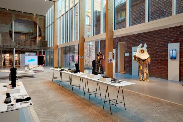 Binnenkant van het gebouw van Schoenenkwartier met tafels met expositie van schoenen