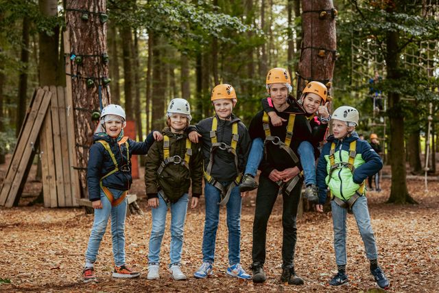 Groepje kinderen met helm op staat klaar om te gaan klimmen in Klim- en Avonturenbos