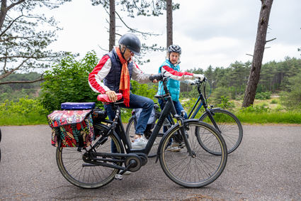 senioren koppel stapt op de fiets