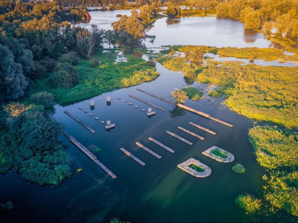 Schanskorven verbeelden de principia van Meinerswijk. Ze zijn omgeven door hoog water in de uiterwaarden.