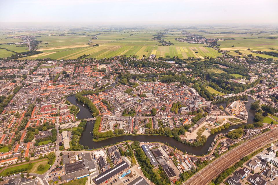 Historisch stadscentrum Woerden in het Groene Hart. Luchtfoto van de vestingstad met singels, grachten, Kasteel Woerden, Petruskerk, station en omliggend polderlandschap met weilanden en landbouwgrond.