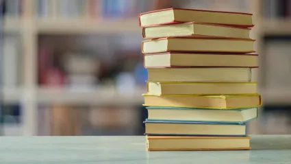 a stack of books on a table in a library