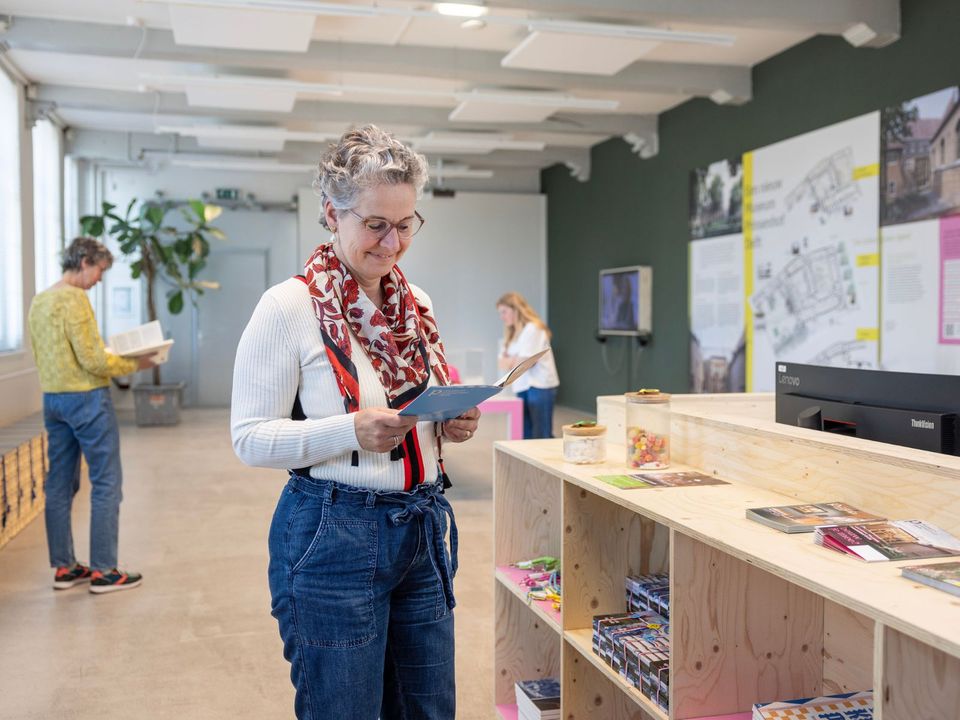 Vrouw leest een informatieboekje in het infopunt