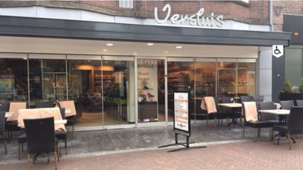 Speciaalzaak Bakkerij Versluis Woerden, provincie Utrecht, Groene Hart, winkelpand met glazen pui en terras aan de Voorstraat in het centrum, bekend om vers brood en banket.