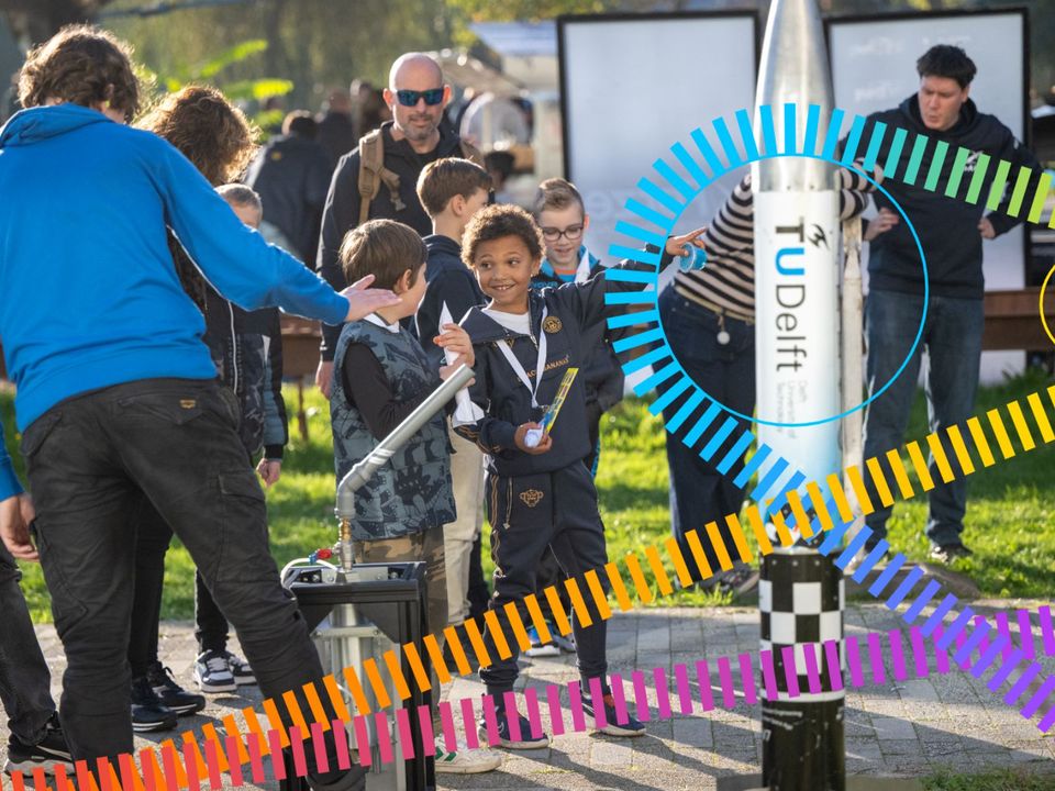Twee jongetjes kijken naar een experiment tijdens Science Day in Delft