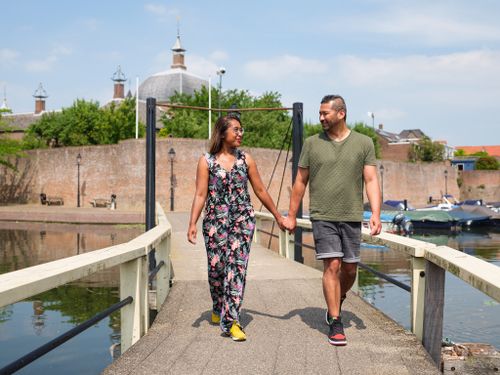Stel loopt over een brug in Leerdam, met de stad op de achtergrond