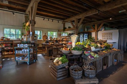 Boerderijwinkel Hof van Gunterstein in Breukelen, Vechtstreek, met manden vol verse groenten en fruit, streekproducten en andere etenswaren in een houten winkelruimte.