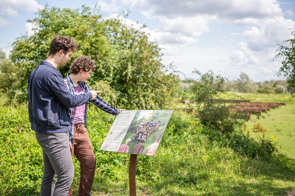 Een jonge man en vrouw staan bij een informatie in de buurt van de principia in Meinerswijk.