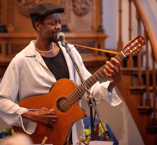 Een man die aan het zingen is en gitaar speelt