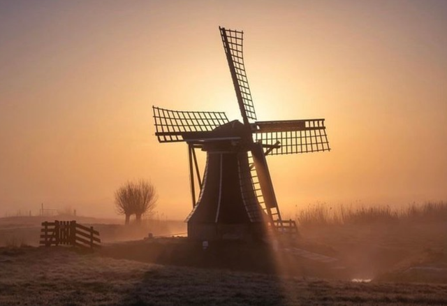 Zons opkomst met uitzicht op een molen