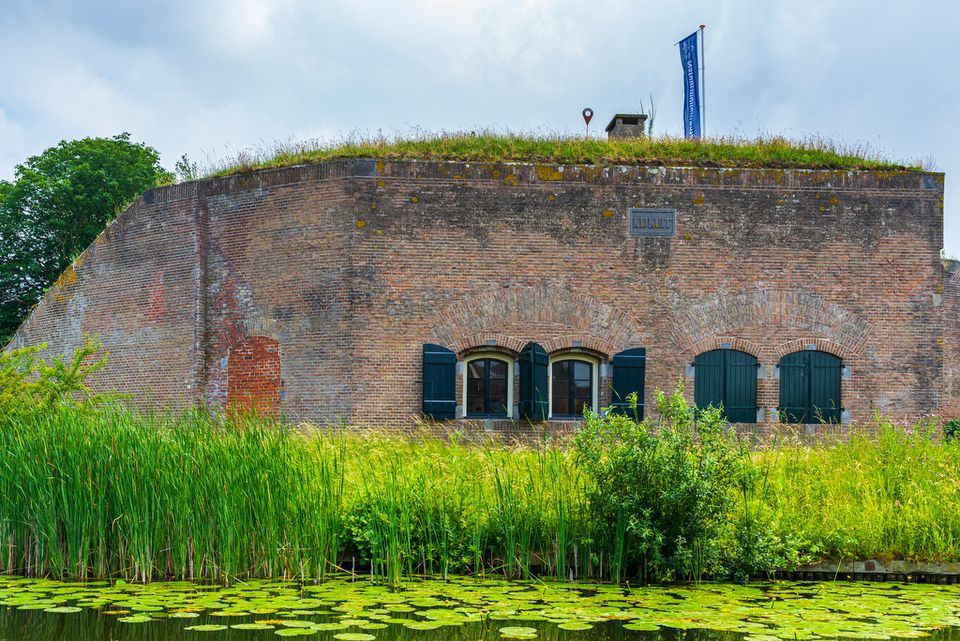Een fort van bakstenen omringd door veel groen.
