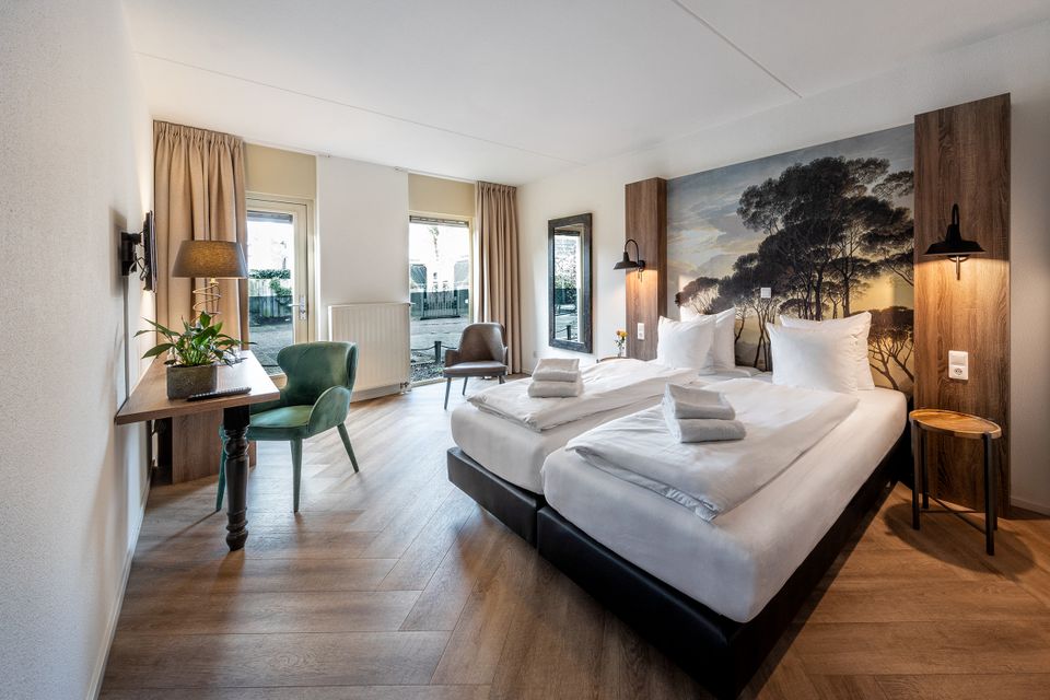 Comfortabele hotelkamer van Hotel en Grand Café Broeck in Oudewater met twee opgemaakte bedden, moderne inrichting, houten vloer en sfeervolle wanddecoratie, geschikt voor een ontspannen overnachting in het centrum van Oudewater in het Groene Hart.