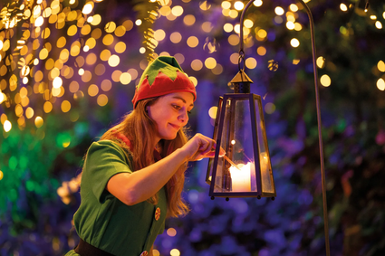 Een elfje steekt de kaarsjes aan tijdens Winterdroom in Pantropica in Luttelgeest.