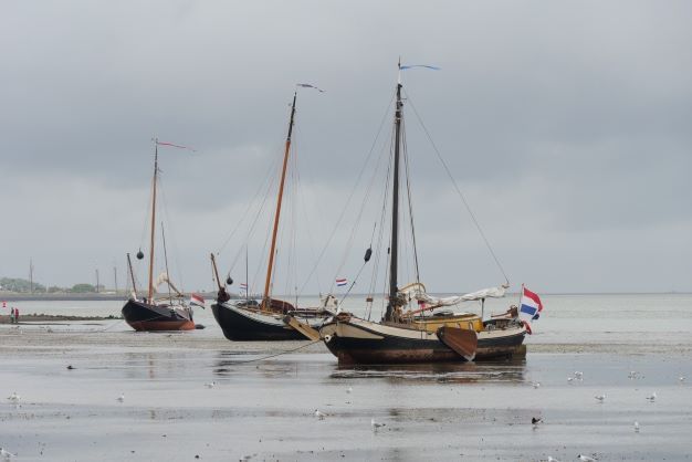drie droogvallende oude boten Vlieland Waddenzee