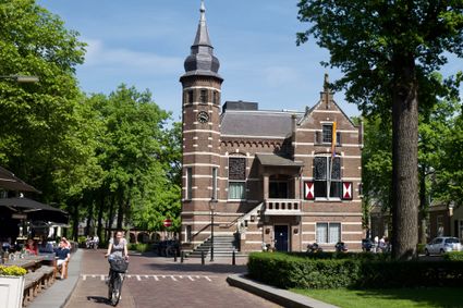 Het Oude Raadhuis in Oisterwijk met terras, fietser en stukje van het Trouwlaantje