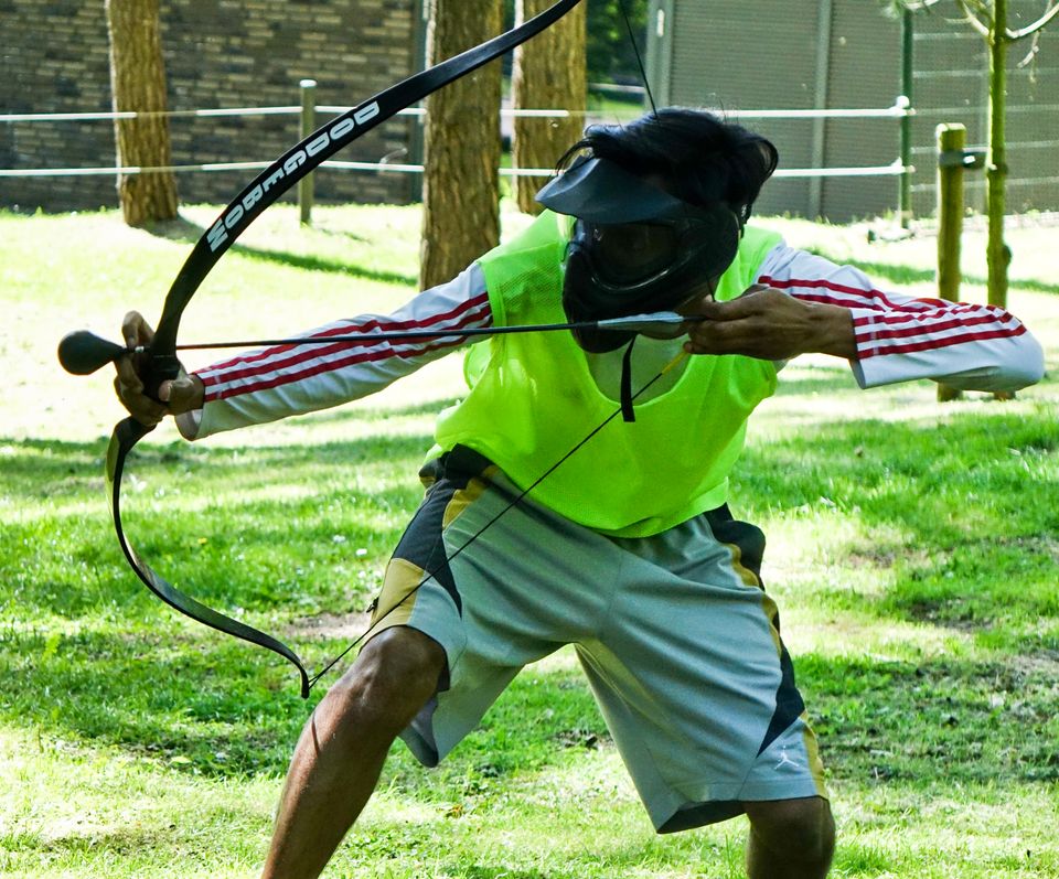 Jongen in geel hesje met pijl en boog
