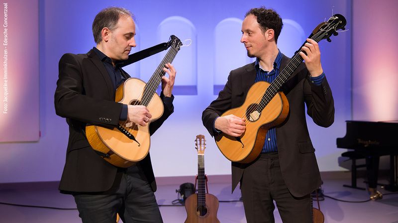 Twee mannen spelend op een gitaar