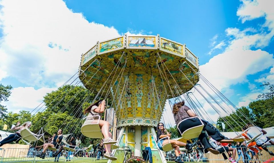 Kermisattractie zweefmolen op de kermis in Woerden, Groene Hart. Draaiende zweefmolen met bezoekers onder een blauwe lucht tijdens een zomerse kermis in de historische binnenstad.