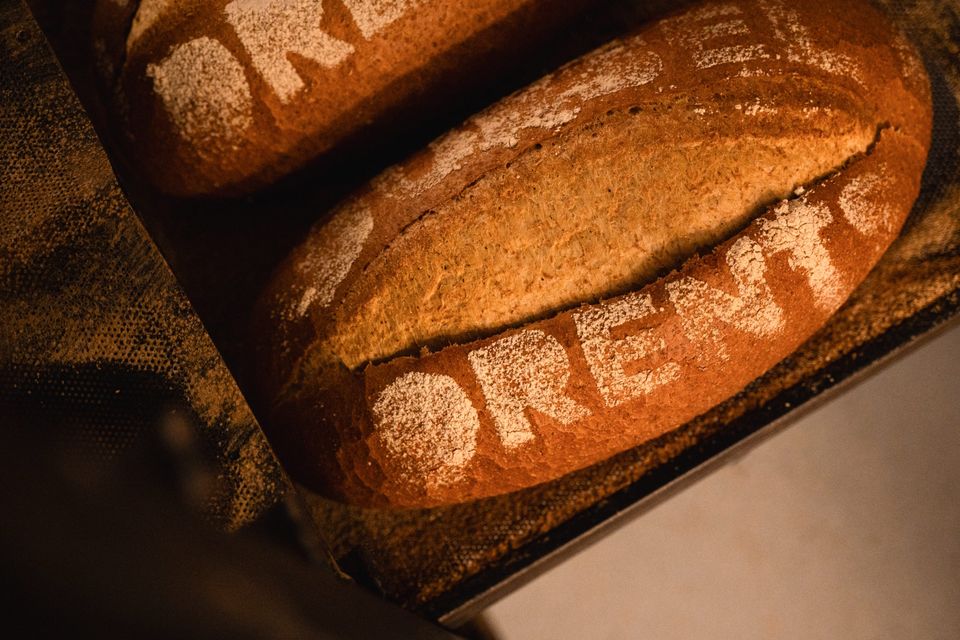 Close-up van een versgebakken brood met daarop 'Dubbel Drents' met bloem geschreven.