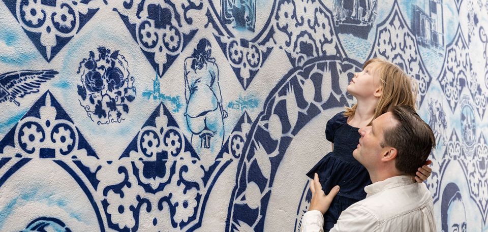 Vader met dochter voor delfts blauwe muur in Delft