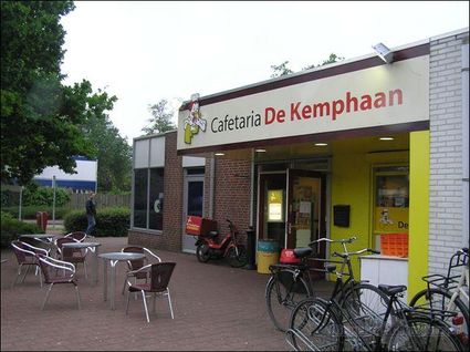 Voorkant snackbar, met fietsen en tafels met stoelen.