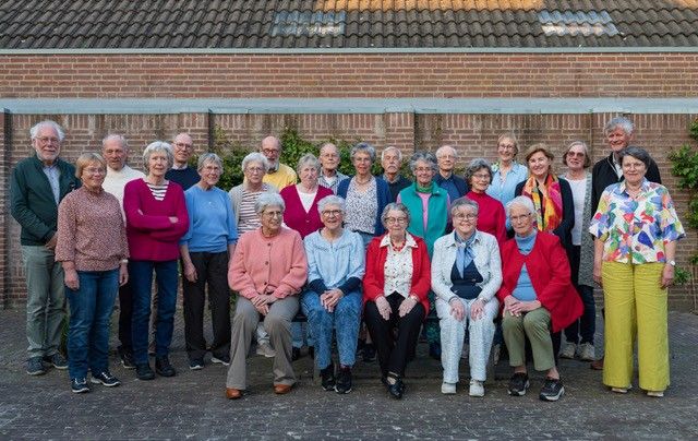 Foto van de zangers en zangeressen in kleurrijke kleding.