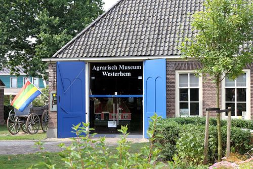 Ingang van Agrarisch Museum Westerhem, blauwe deuren en groene planten op de voorgrond