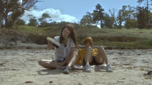 Previously Unreleased, Still uit Arraggame Fuerte. Man en vrouw op het strand