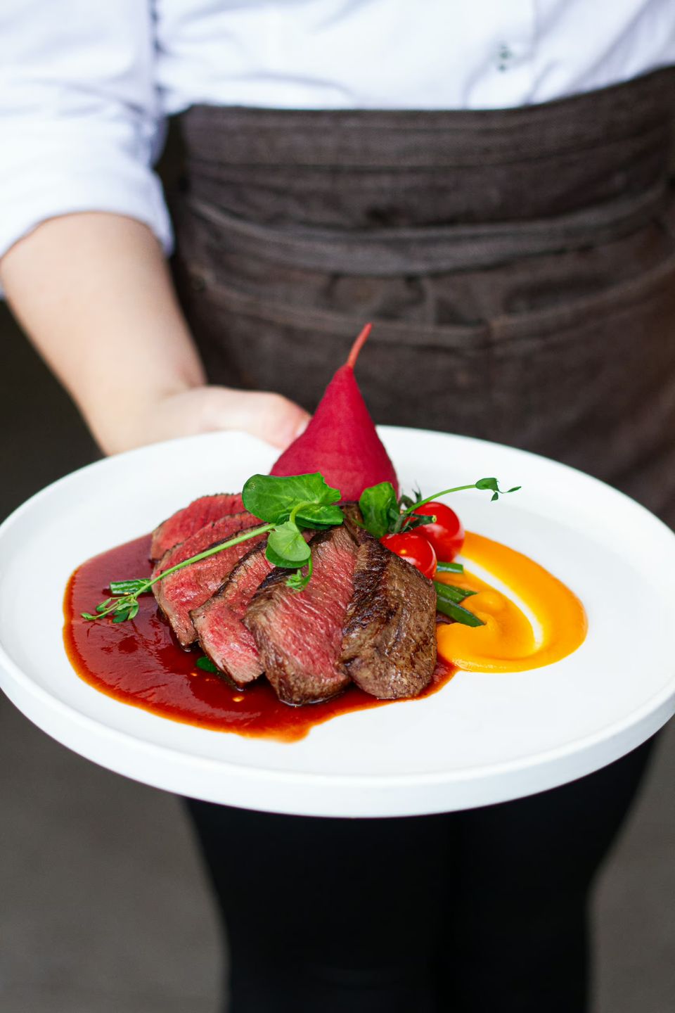 Biefstuk in stukken gesneden met een gestoofd peertje erbij