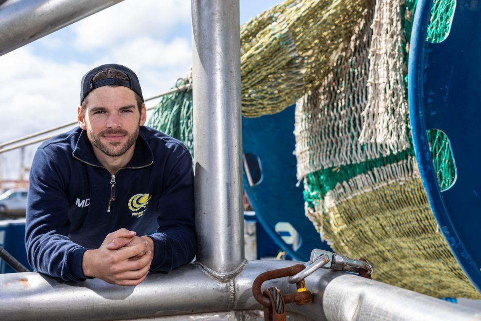 Een visser leunend op een schip in Flevoland