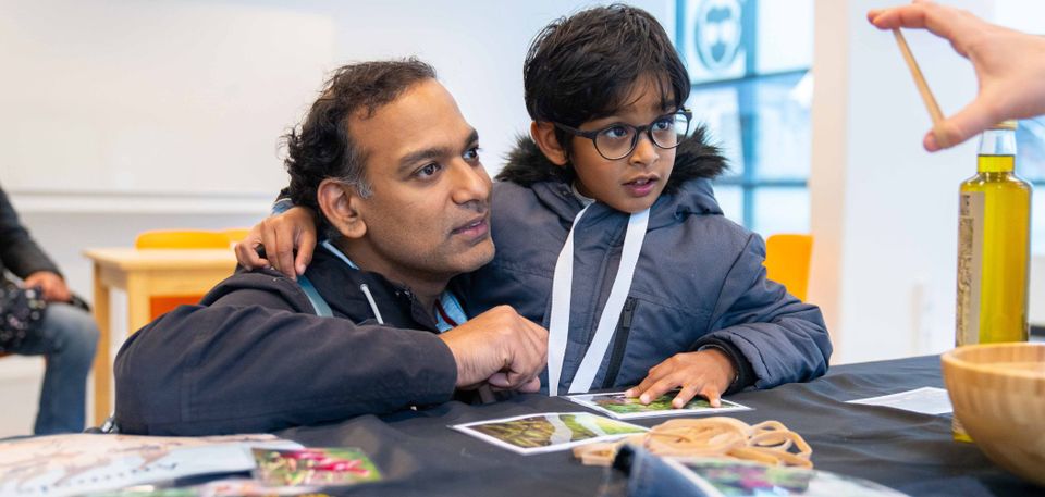 Jongen en vader kijken samen naar een experiment tijdens science day