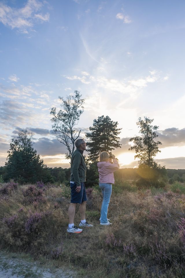 Man en vrouwen kijken naar uitzicht over Landgoed Den Treek-Henschoten