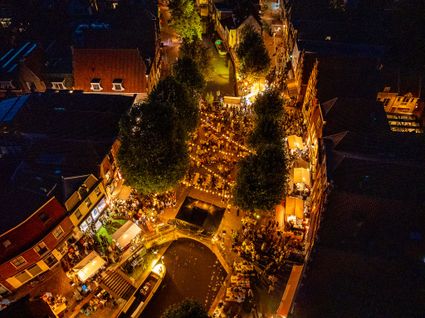 Stedelijk evenement Pracht aan de Gracht in Oudewater, Groene Hart, avondbeeld met verlichte grachten, brug, historische panden en drukbezochte terrassen langs het water.