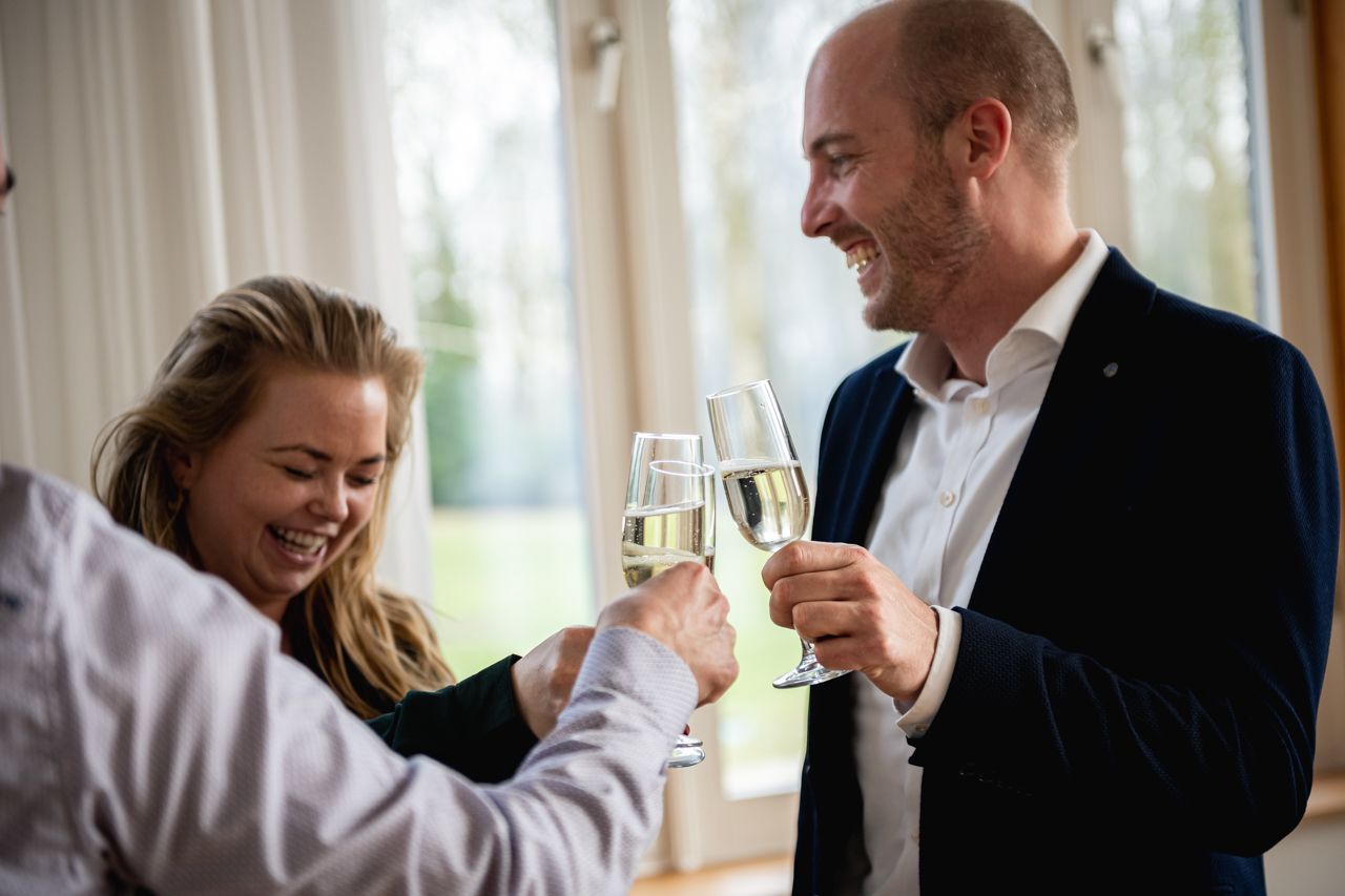 Drie mensen proosten tijdens een borrel