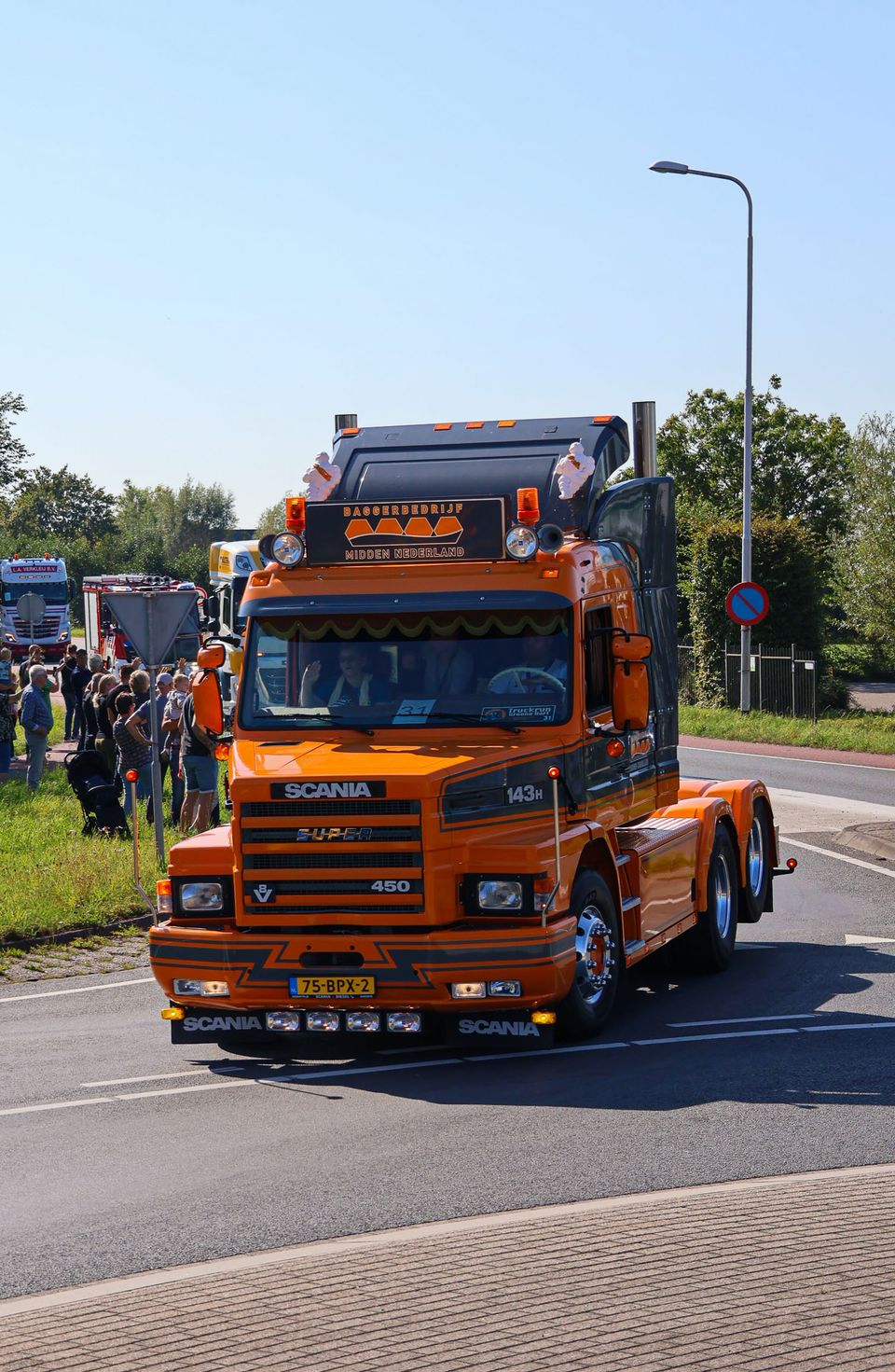Oranje Scania-vrachtwagen rijdt mee tijdens de Truckrun Groene Hart, een feestelijke optocht voor mensen met een beperking.