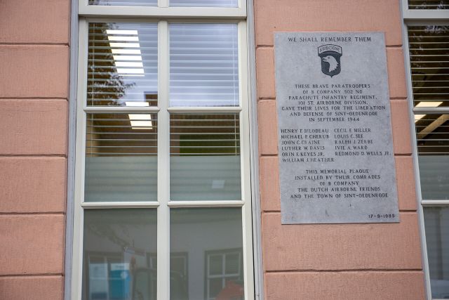 Op de muur van het voormalige raadhuis van Sint-Oedenrode hangt een plaquette. ‘We shall remember them’, staat er bovenaan.