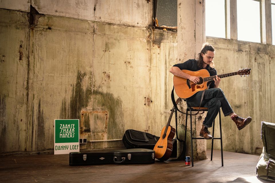 Man die gitaar speelt in het Hem