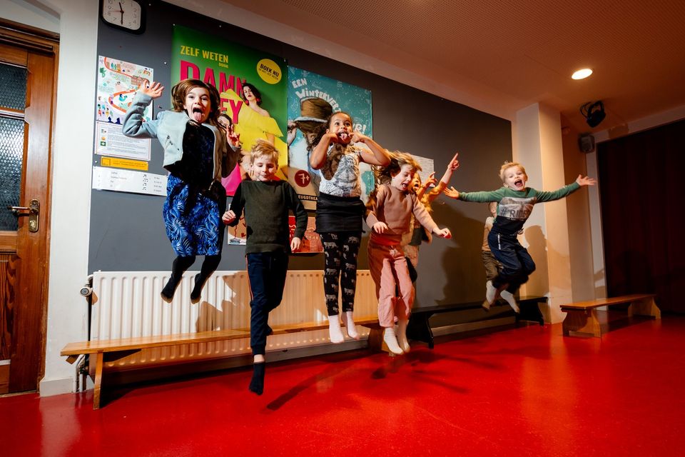 Culturele locatie theater Het Klooster, Woerden, Groene Hart, groep kinderen die spelenderwijs springen en bewegen in de foyer tijdens een creatieve activiteit of workshop.