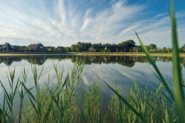 Om een grote waterplas staan enkele luxe bungalows.