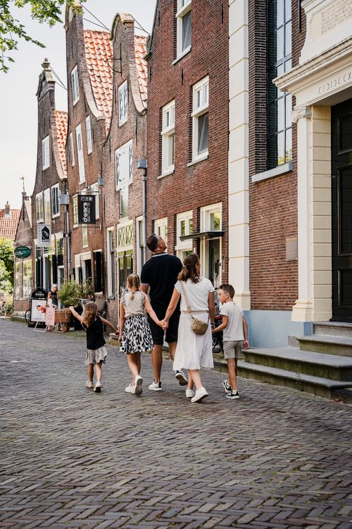 Mensen die langs kaaspakhuizen lopen in Edam