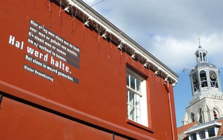 Gedicht op gebouw met Peperbus op achtergrond.