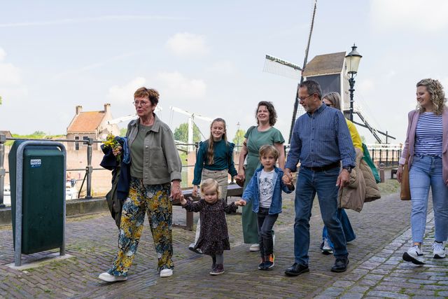 Een groep volwassenen en kinderen lopen de spreekwoordenroute in vestingstad Heusden.