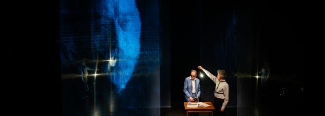 Vincent Bijlo staat op het toneel voor projectie