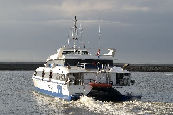 De snelboot Tiger vertrekt. Aan de onderkant van de boot zien we, dat het een catamaran is.
