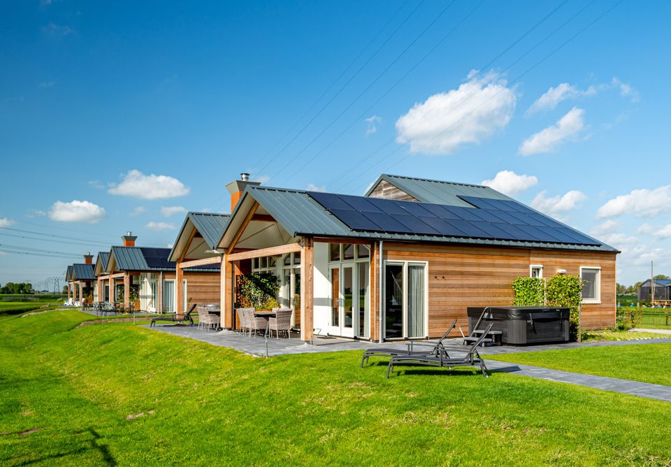 Meerdere vakantiehuisjes met zonnepanelen bij Tusken de Marren in Akkrum op een rij.