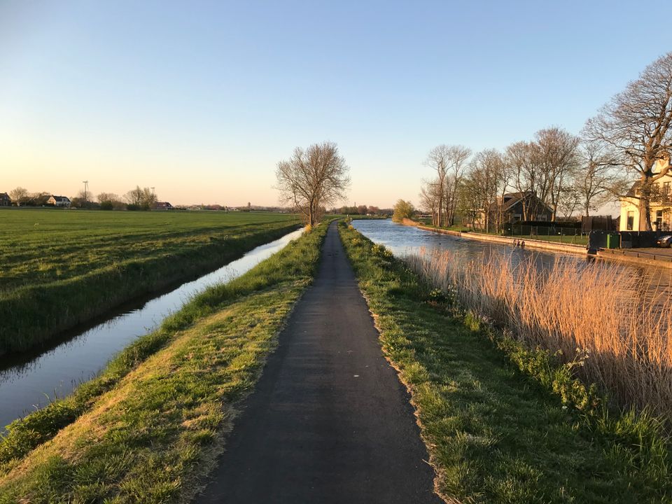 een pad met aan de zijkant een meer en huizen